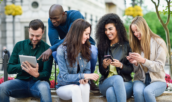 Multi-ethnic young people using smartphone and tablet computers